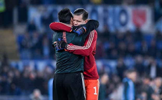 Szczesny y Buffon se abrazan en un partido de la Juventus.  AFP