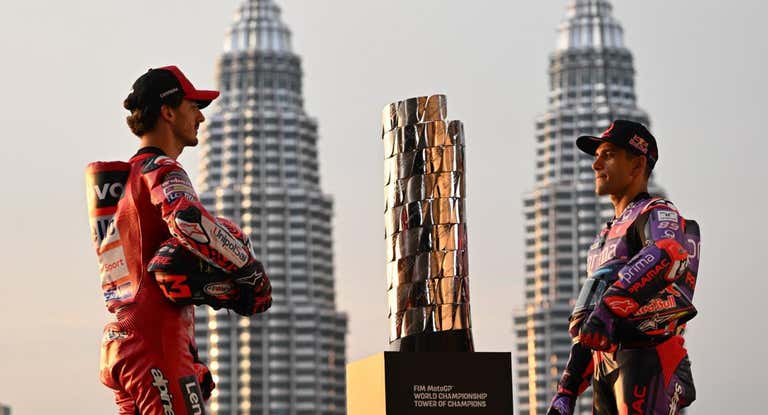 Bagnaia y Martín posan junto al trofeo de MotoGP frente a las torres Petronas de Malasia.