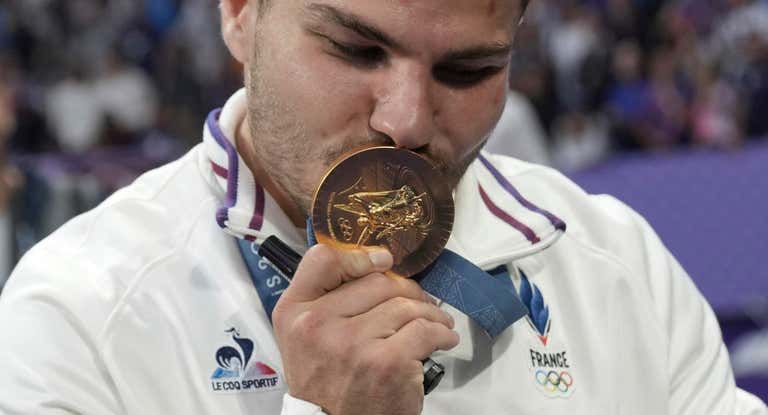 Dupont besa la medalla de oro olímpica.
