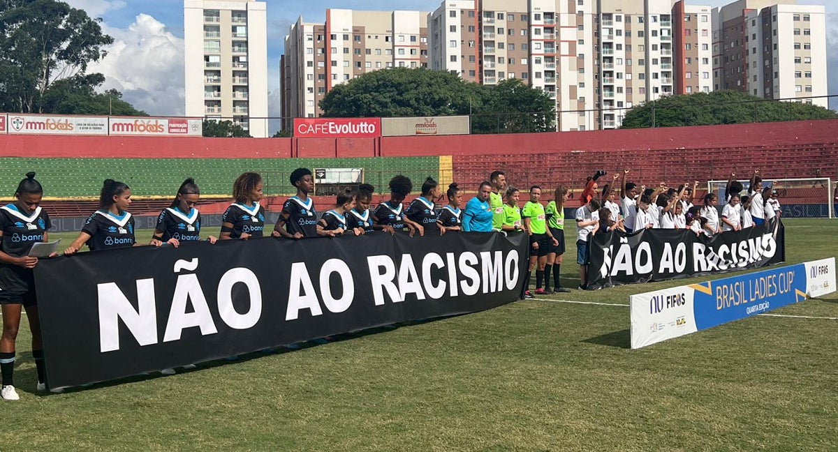 Jugadoras de Gremio posan con pancartas en contra del racismo en la Brasil Ladies Cup tras lo sucedido con River Plate.