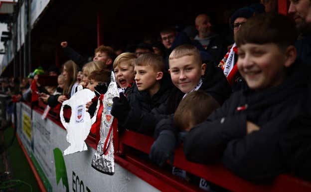 Niños aficionados del Tamworth sostienen una FA Cup. REUTERS