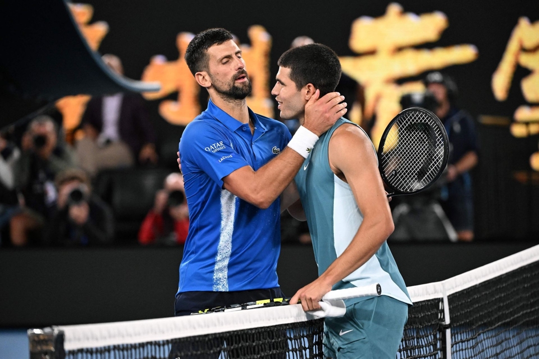 Novak Djokovic y Carlos Alcaraz se saludan tras su último duelo, en los cuartos de final de Australia 2025.  WILLIAM WEST / AFP