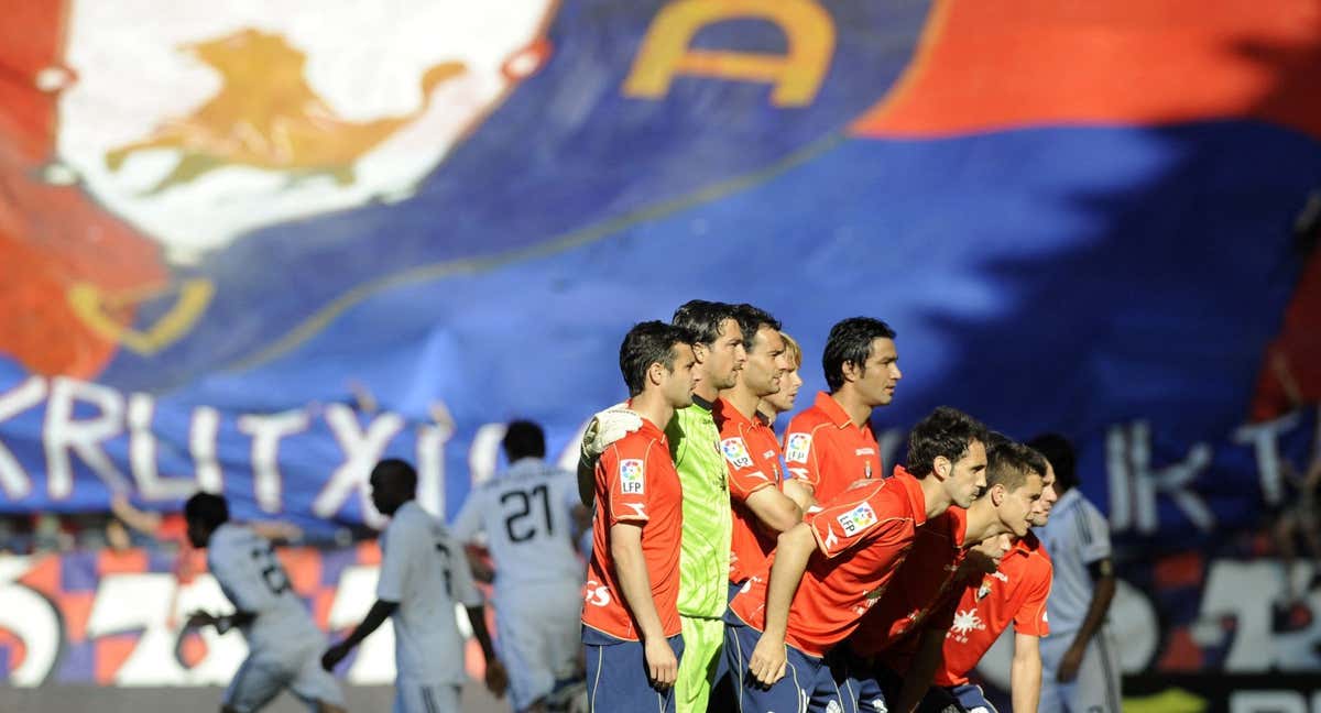 La bandera de Osasuna, desplegada en un fondo de El Sadar, en un partido contra el Real Madrid. /AFP