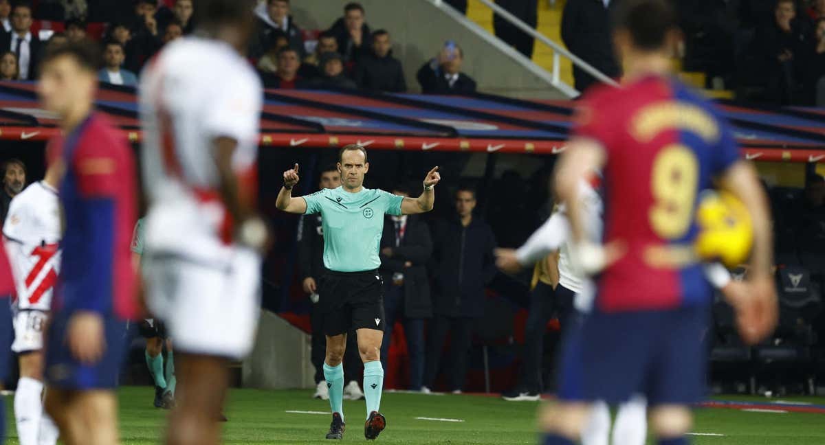 El árbitro Mario Melero señala una infracción tras consultar el VAR en el FC Barcelona-Rayo Vallecano. /REUTERS/Albert Gea