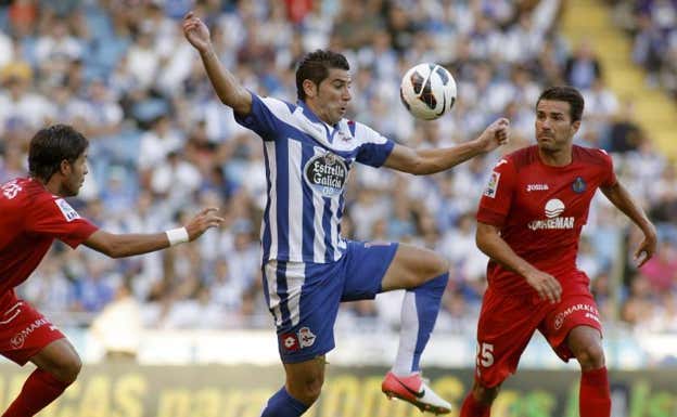 Riki, del Dépor, pelea por un balón con Xavi Torres y Miguel Torres, del Getafe. ARCHIVO