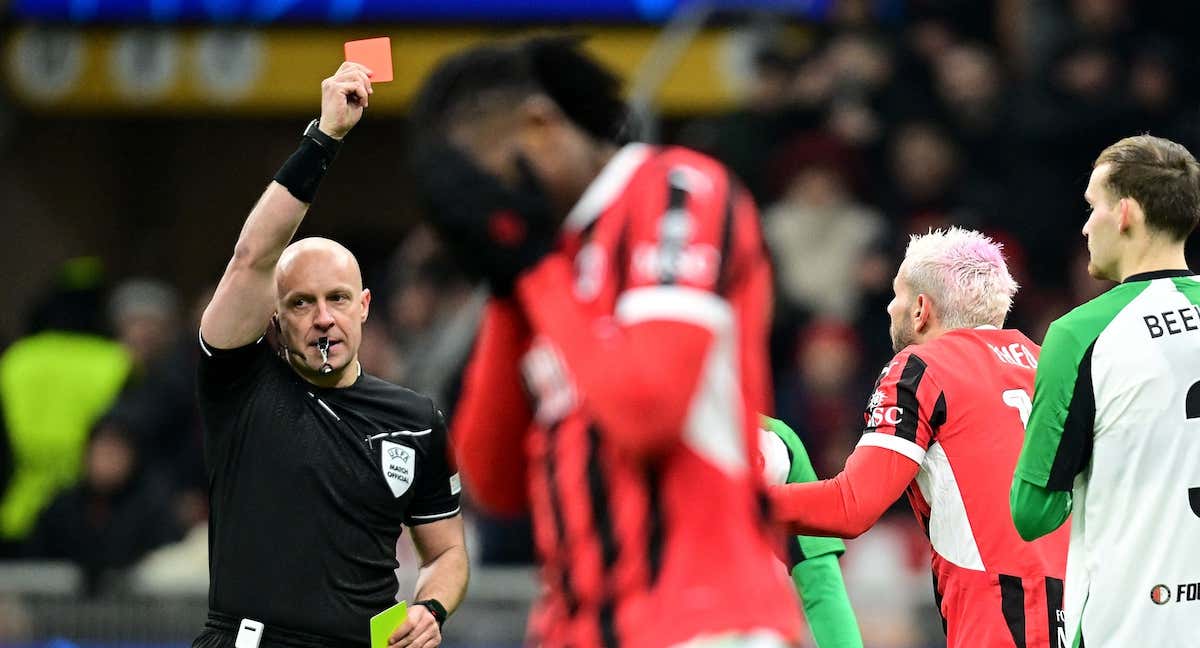 Szymon Marciniak muestra una tarjeta roja durante un partido de la Champions League.