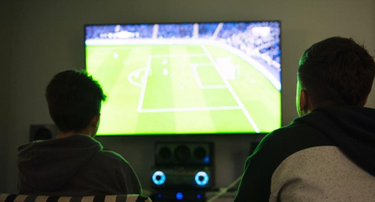 Dos personas ven fútbol de manera ilegal. F