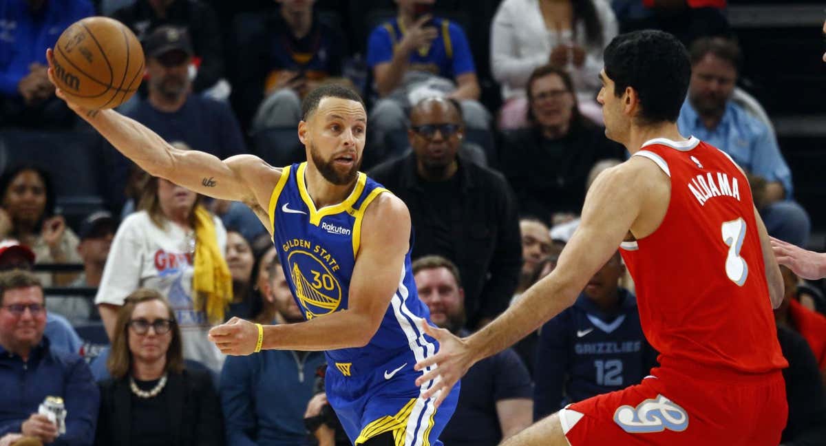Santi Aldama intenta frenar a Stephen Curry.